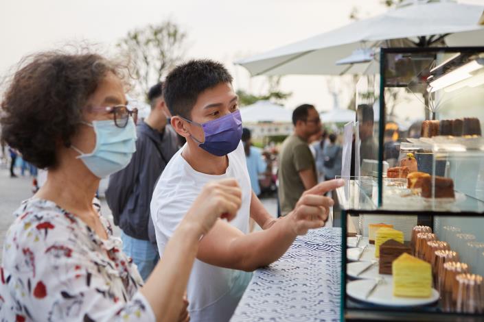 圖5.攤車品牌經營者向有興趣民眾介紹攤車販售的創意甜點。