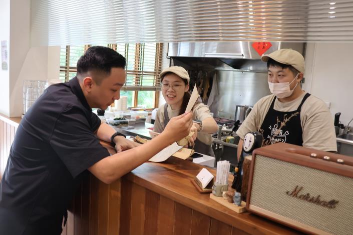 圖2.開放透明的烹飪環境，令顧客安心食用。圖為青年局長張以理(左一)親訪青創店家「小燉食室」，與業者互動交流。.JPG