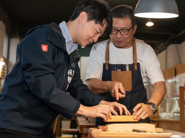 坐落Pinway青創基地二樓的「大雄的木作世界」，負責人盧秀雄（右）親自帶領高市青年局長林楷軒（左）體驗刨製木筷的手作樂趣。
