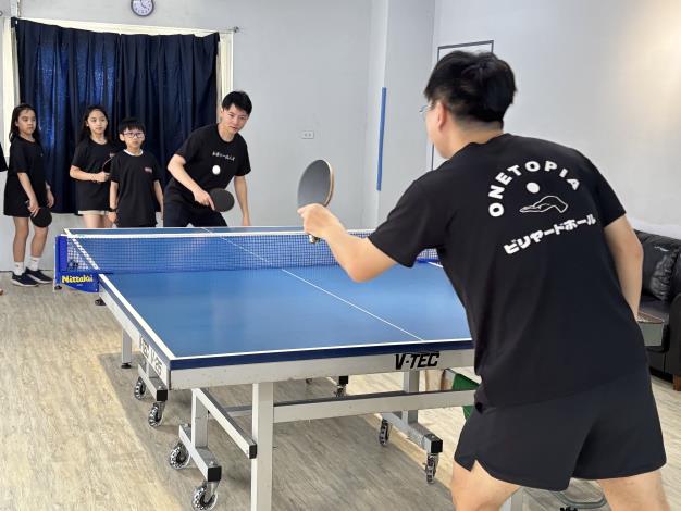圖2.高市青年局長林楷軒(圖後接球者)日前參訪「玩樂倉庫」和創辦人李杰恩交流產業現況，也上場小試身手揮拍練打。