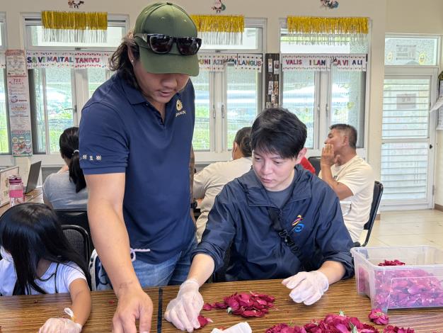 參訪「杉恆壹樹」的青年局長林楷軒（右），挽起袖子與社區居民一同加工玫瑰。