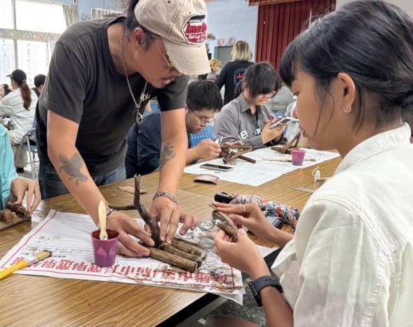 圖2：《透南風》雜誌創辦人余嘉榮老師(左)指導學員如何使用漂流木製作燭台，在創作中思考海洋環境與永續議題。