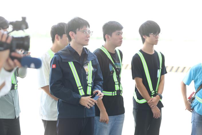 青年局長林楷軒（左）與學員穿戴反光背心，仔細聆聽航務員講解空側注意事項與機場航務作業流程。.JPG