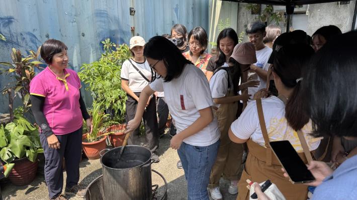 圖說二：初冊文化活動組長陳梅老師（左一）指導青年以菱角殼熬製染料，體驗傳統染布工藝。