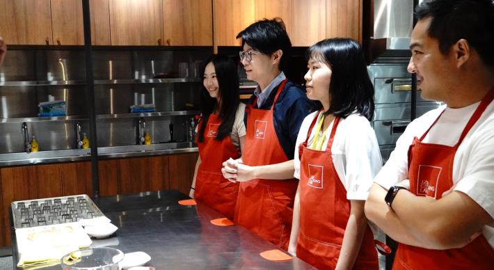 青年局長林楷軒（右三）與實習生穿上紅色圍裙，於舊振南漢餅文化館裡學習漢餅製作工序，一窺爆紅鳳梨酥背後的迷人魅力。