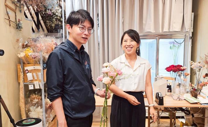 圖2. 青創品牌「艸弄花藝」負責人許琇淳（右）詳細解說花語，並指導青年局長林楷軒（左）搭配花朵組合成富有涵義的母親節特色花束。