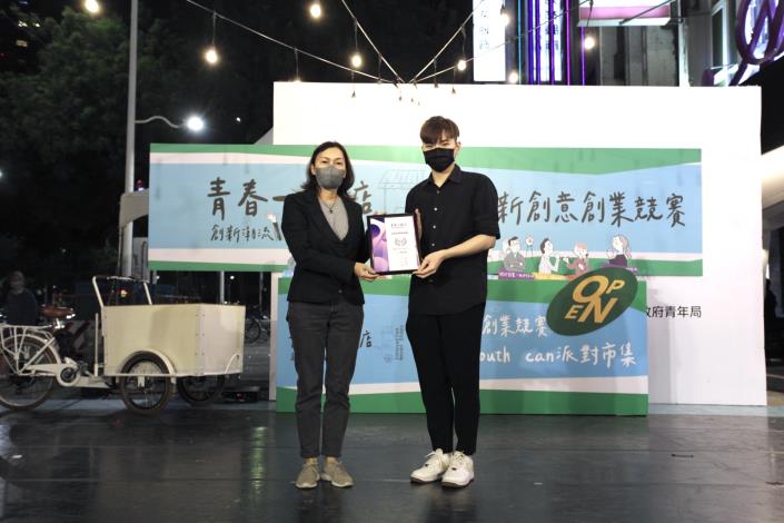 圖5.吳虹醫師(左一)頒發「青春一號店」創業競賽最受市場喜愛獎獎項給晝暮酒食，獲獎團隊另可獲得媒體採訪機會。
