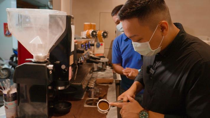 圖1.高雄市政府青年局長張以理(右)訪視110年青創補助店家「琲甞咖啡」參與咖啡製作過程