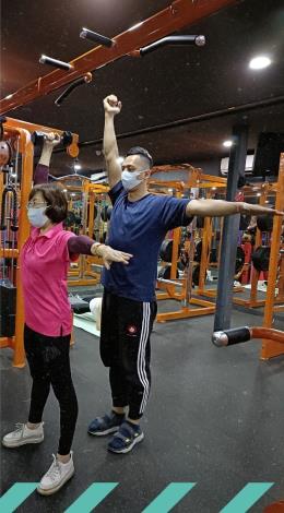 圖2.運動是對抗退化最佳利器，圖為專業教練一對一指導女性會員鍛鍊肩頸三角肌肉群