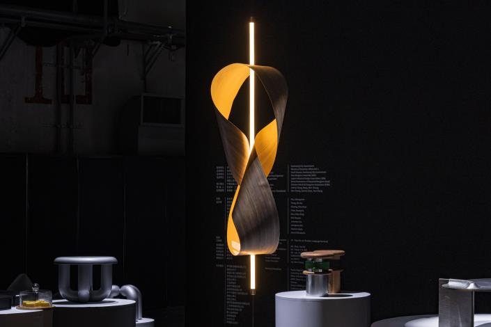 4.Studio Shikai曾熙凱設計師則取材高雄在地木皮工廠，透過木皮的扭轉旋繞製作而成燈具－Wood Ribbon 。