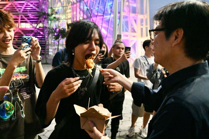 圖8.高雄市長陳其邁逛市集一路開吃，還將攤車美食與年輕朋友分享。