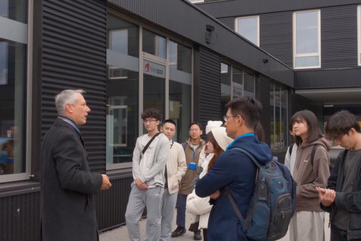 圖2.慕尼黑工業大學代表（左一）向見習團學員介紹校內環境與Makerspace（創客空間）等設施，學員專注聆聽，實地感受德國創新教育與實務結合的學習氛圍。