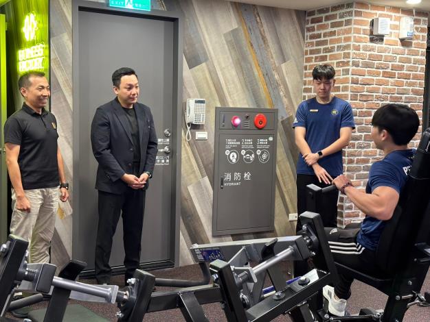 圖1.健身工廠實習生（右一）向青年局局長張以理 (左二)及健身工廠總經理林洵賢 (左一)示範如何正確操作健身器材。
